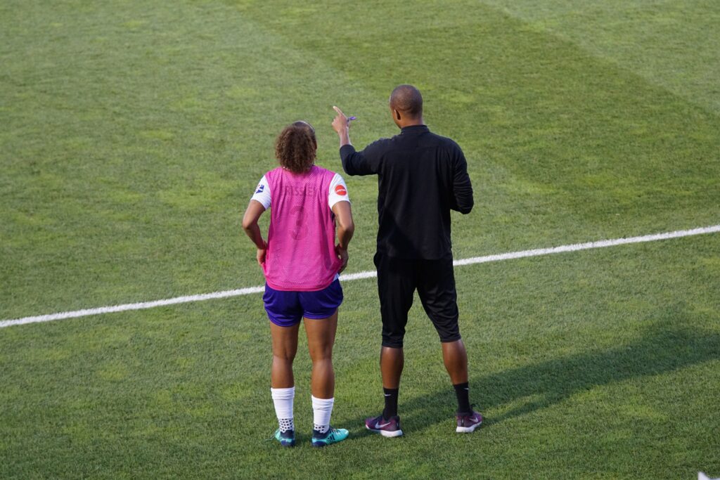 soccer coach guiding a player